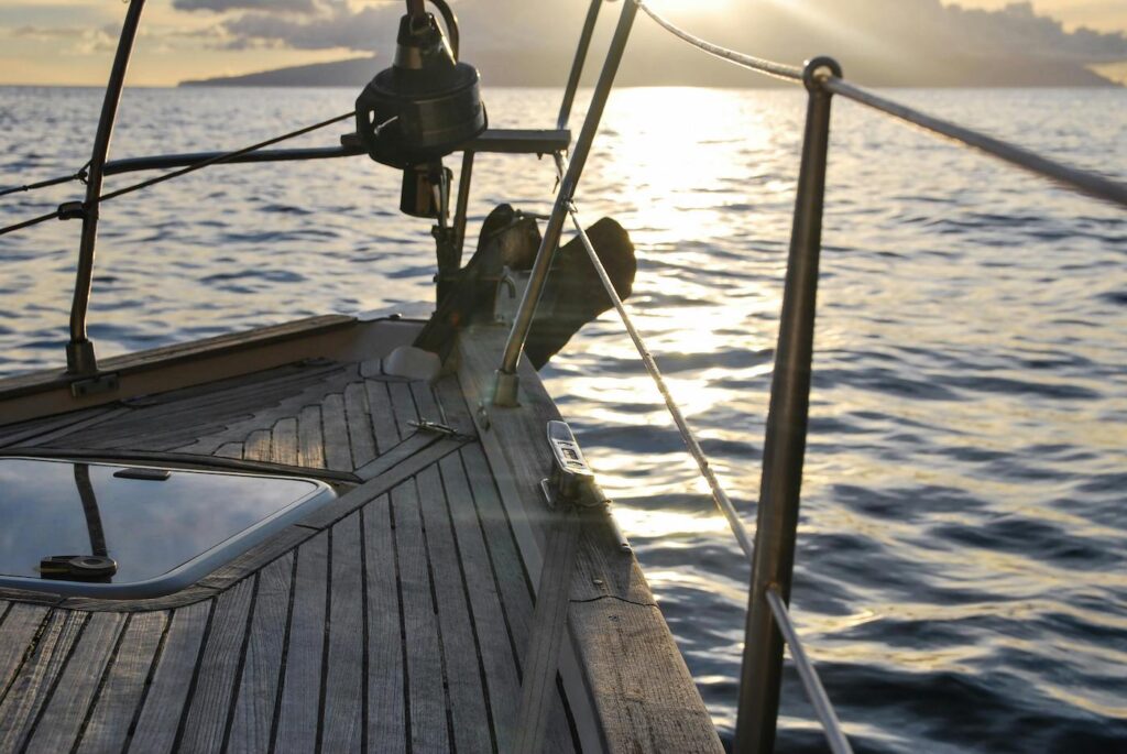 A small wooden ship with fishing supplies is sailing across the ocean.