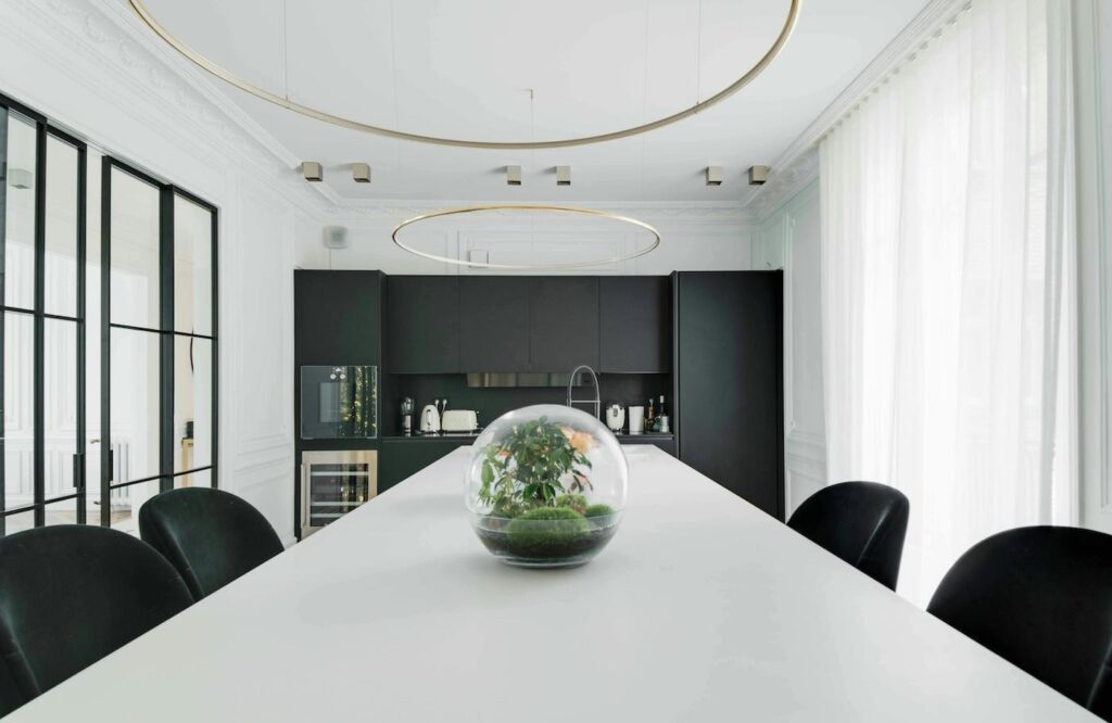 a brightly lit conference room with a long table stretching down the middle of the room, with a floral arrangement as the centerpiece.